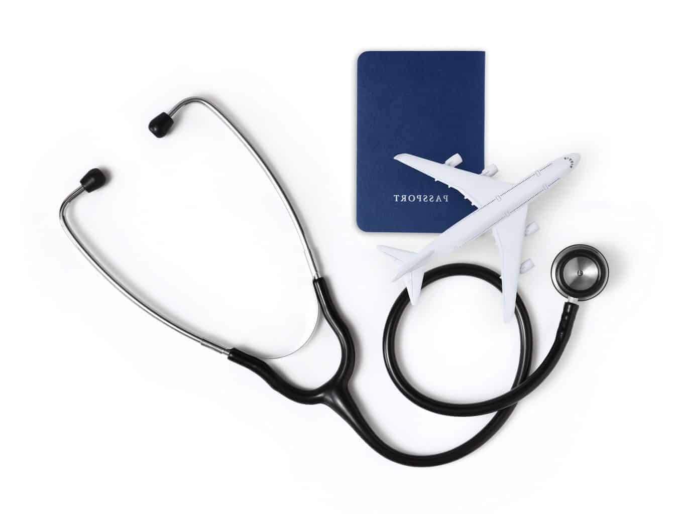 Grouped image of a small white aeroplane lying over a blue travel passport and stethoscope representing international travel health.