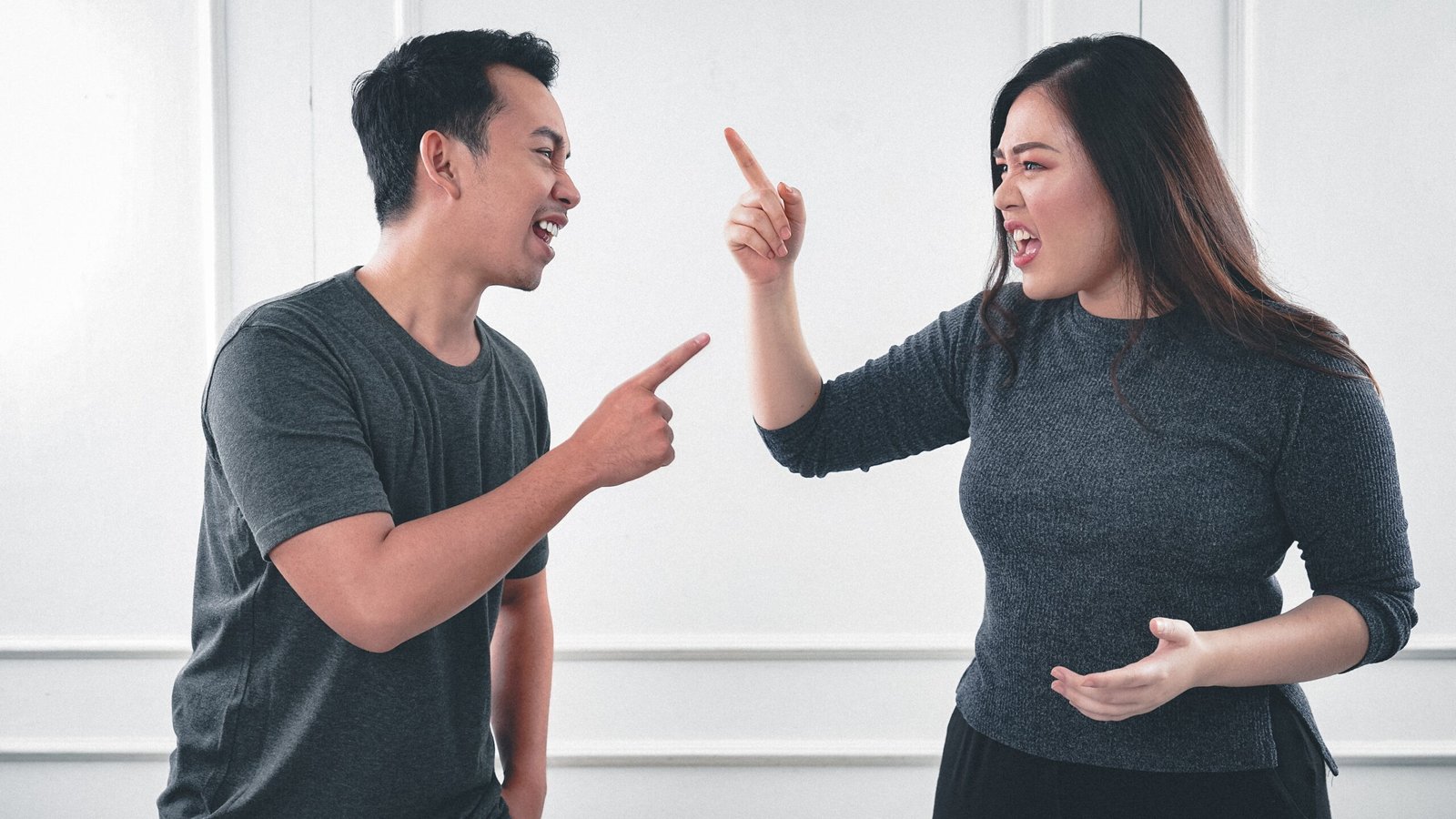 Ten signs you are sabotaging your marriage now 1 An Asian couple is having a heated argument screaming and pointing rudely at each other.