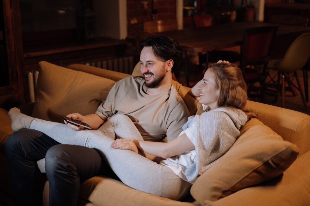 A couple relaxing in their couch watching a romantic movie content that they are meeting the emotional needs in a relationship