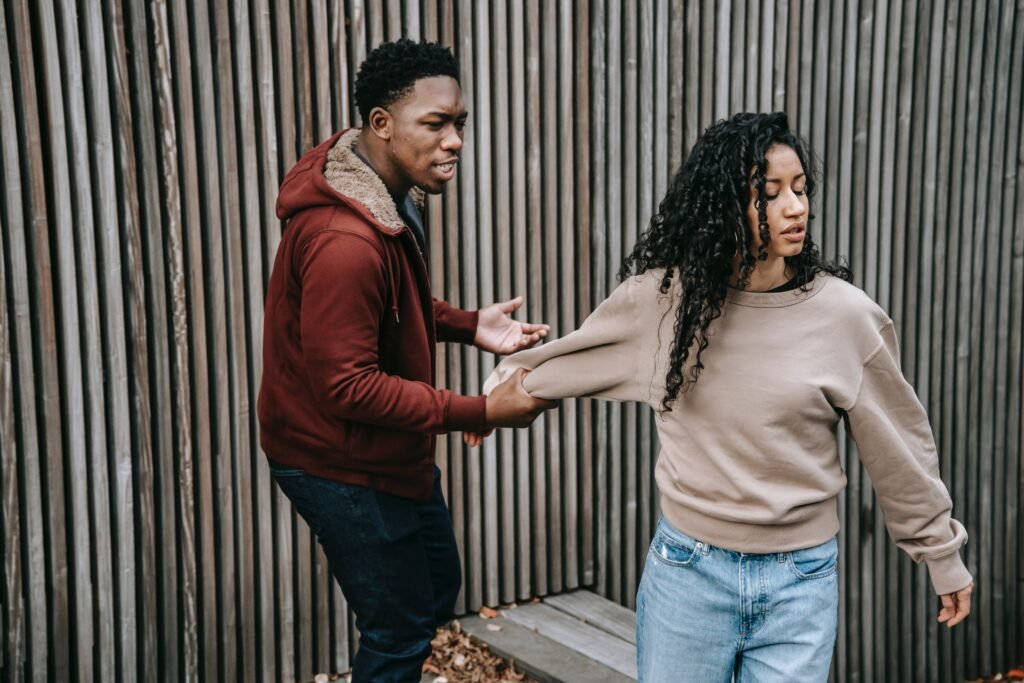 Beware of these six love busters in your marriage 3 A Black couple engaged in marital conflict with the husband pulling back his wife on the right arm as she attempts to get away.