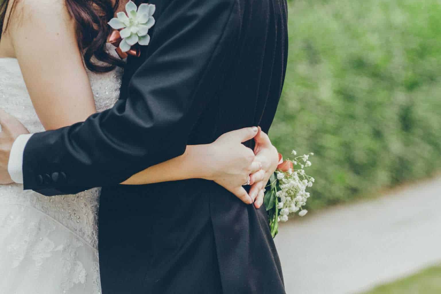 A couple on their wedding day cuddles together while exchanging marriage vows.