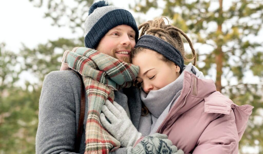 The vital emotional need for companionship in marriage 1 A young couple dressed in Winter wear while cuddling and happy about meeting their emotional need for companionship in marriage