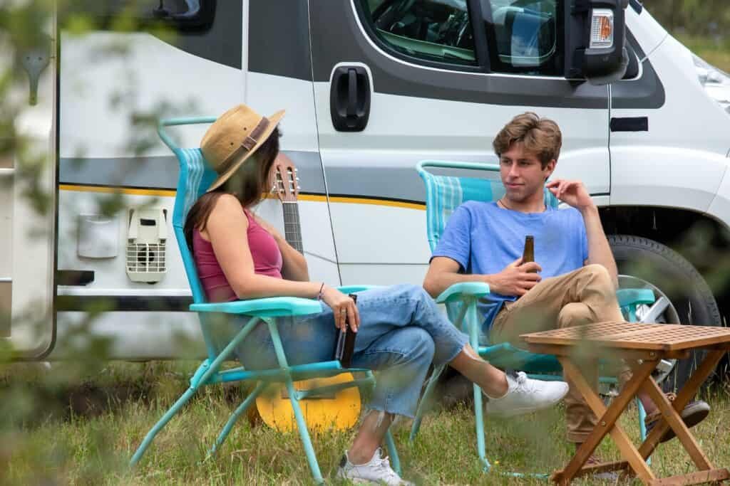 The vital emotional need for companionship in marriage 2 A young couple camping beside their motorhome sipping a drink and happy about meeting their emotional need for companionship in marriage