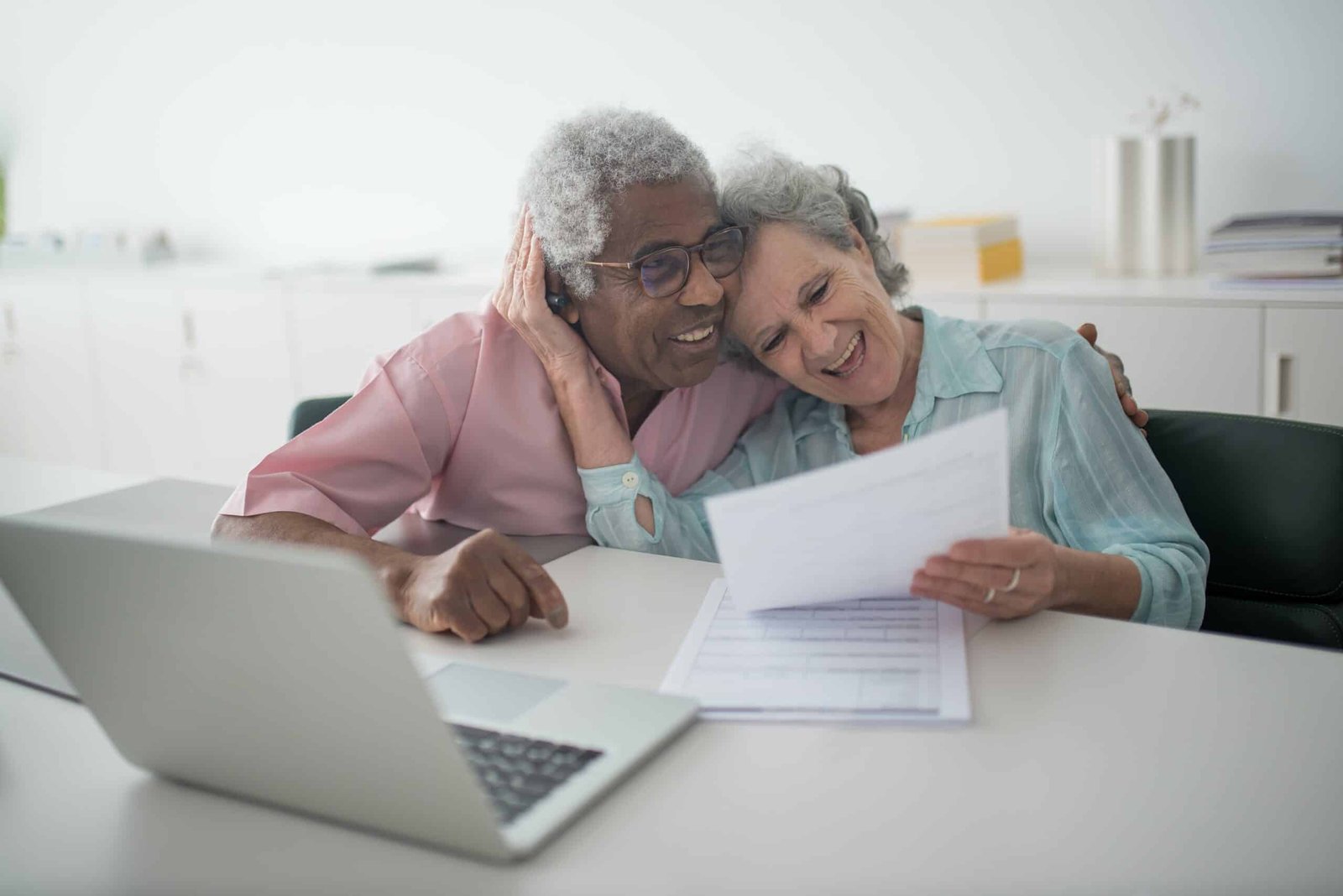 An older couple happily cuddling each other while reviewing their tax returns exemplifying my blog niche of relationships.