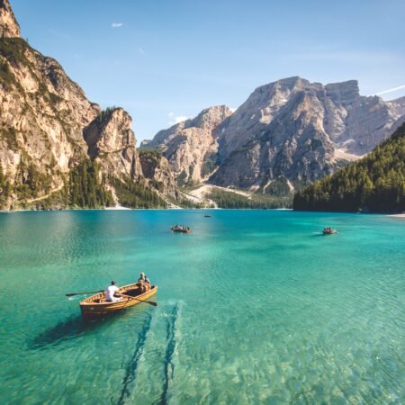 A man canoeing on a clear blue sea facing picturesque mountainous peaks as opportunity knocks for a wonderful adventure