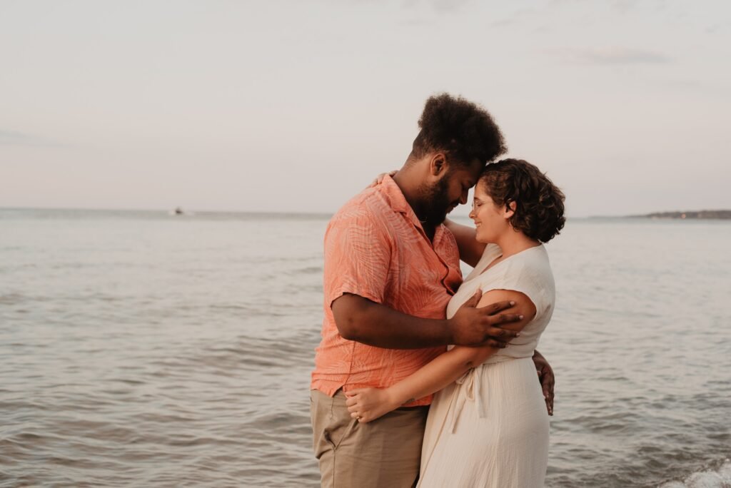 Emotional Connection in Marriage: Keys to lasting love 2 A Black couple cuddling along the beach as a sign of emotional connection in marriage
