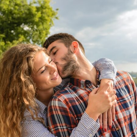 A biracial couple hugging and kissing as a sign there are emotionally connected in marriage