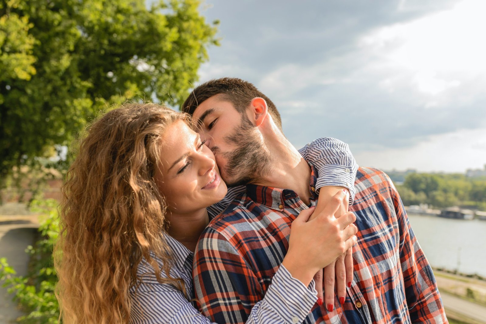 A biracial couple hugging and kissing as a sign there are emotionally connected in marriage
