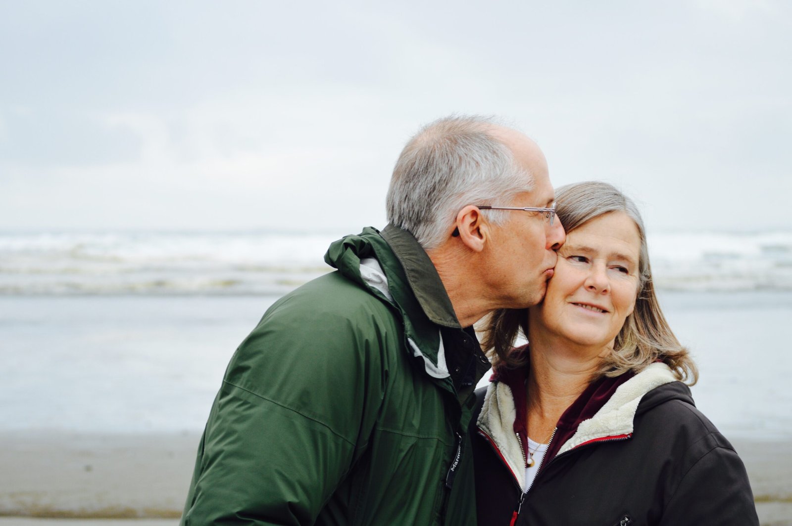 A couple kissing on the beach, one of the signs of a healthy relationship.