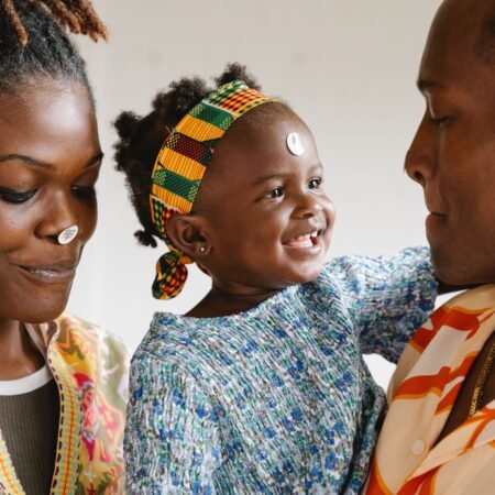 A Black couple with their smiling daughter as a sign of commitment in relationships