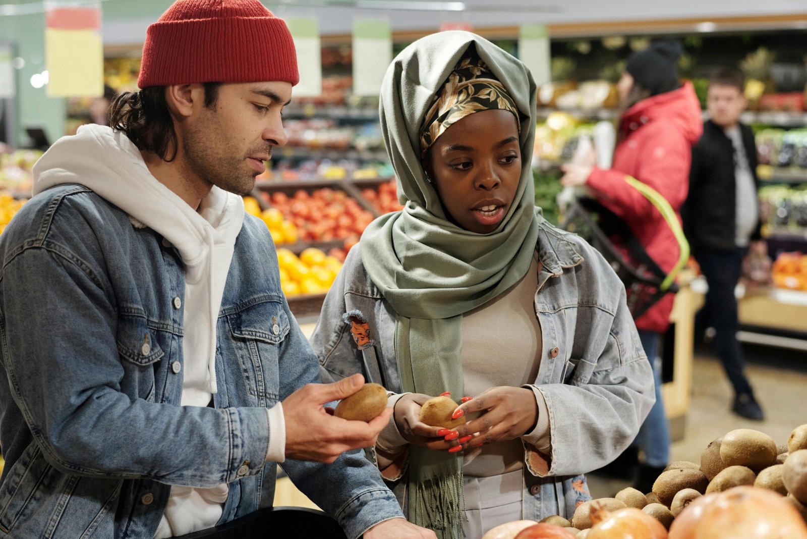 A multiracial couple shopping in the fruit market, heeding to advice from their relationship coach to "nurture your relationship"