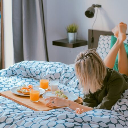 A lady enjoying breakfast while laying on the bed on her birthday while contemplating her self-discovery journey.