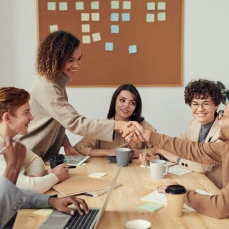 Team members shaking hands at the end of a presentation on maintaining professional boundaries at the workplace.